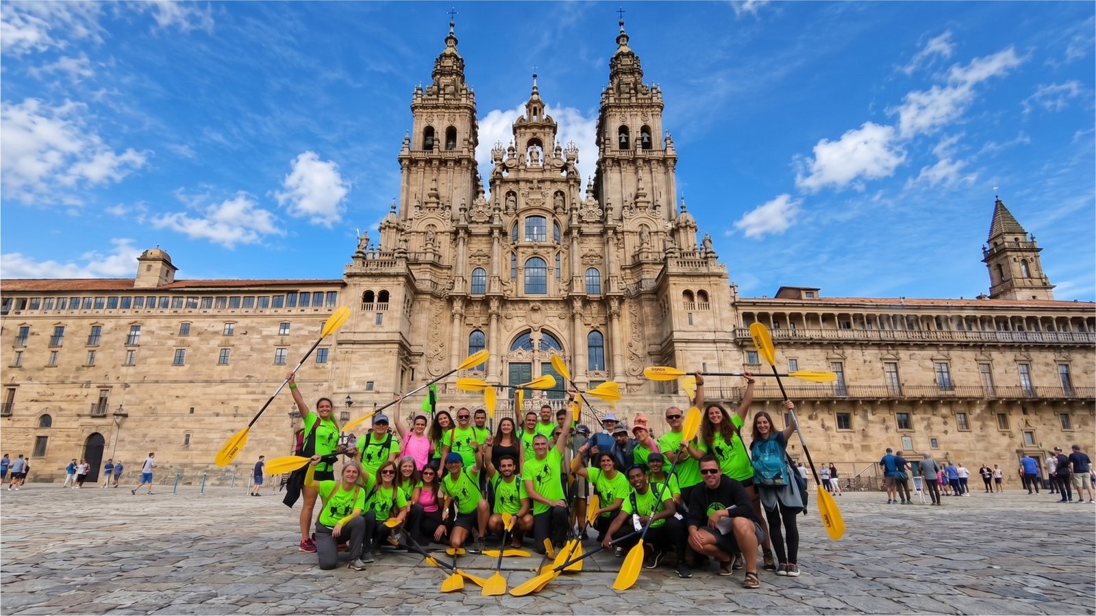 Grupo de Peregrinos del Mar con las palas en alto frente a la catedral de Santiago de Compostela