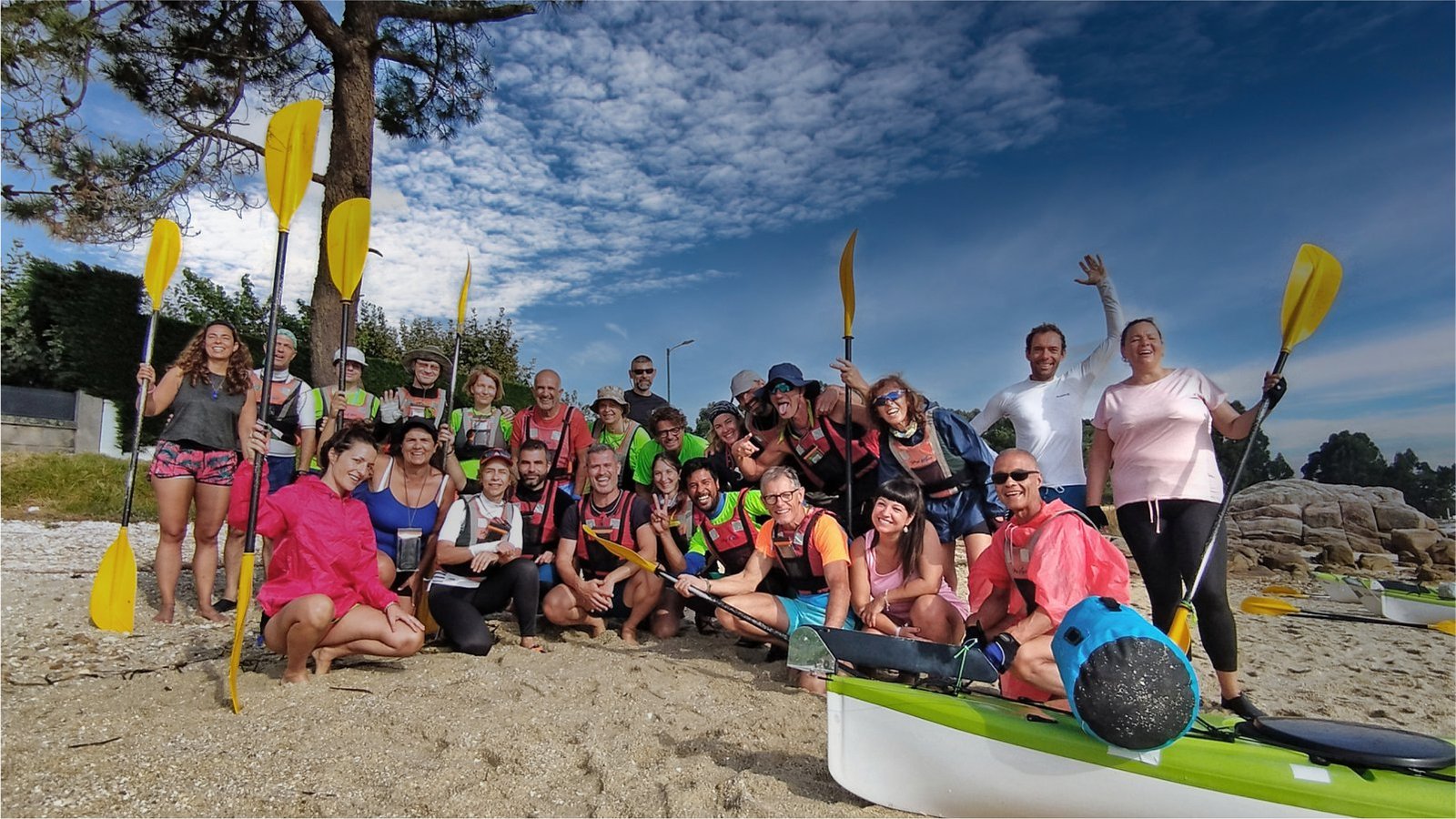 Grupo de kayakistas en la playa junto a sus embarcaciones